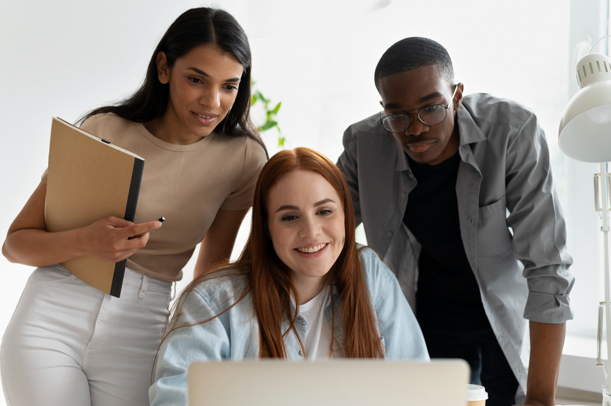A diverse group of professionals engaged in an active brainstorming session around a table in a modern office.