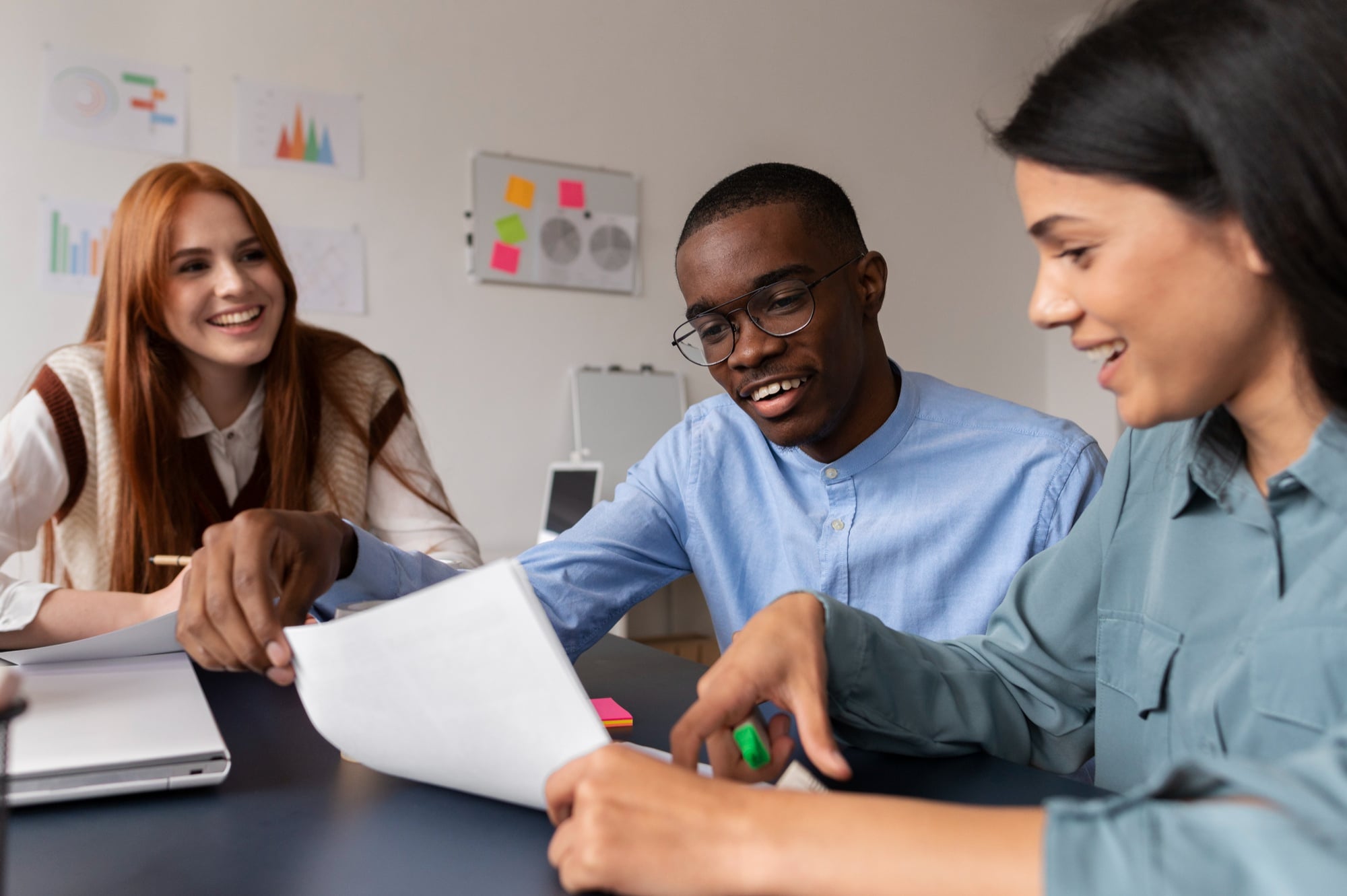 A diverse group of professionals engaged in an active brainstorming session around a table in a modern office.